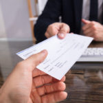 Businessperson Giving Cheque To Colleague